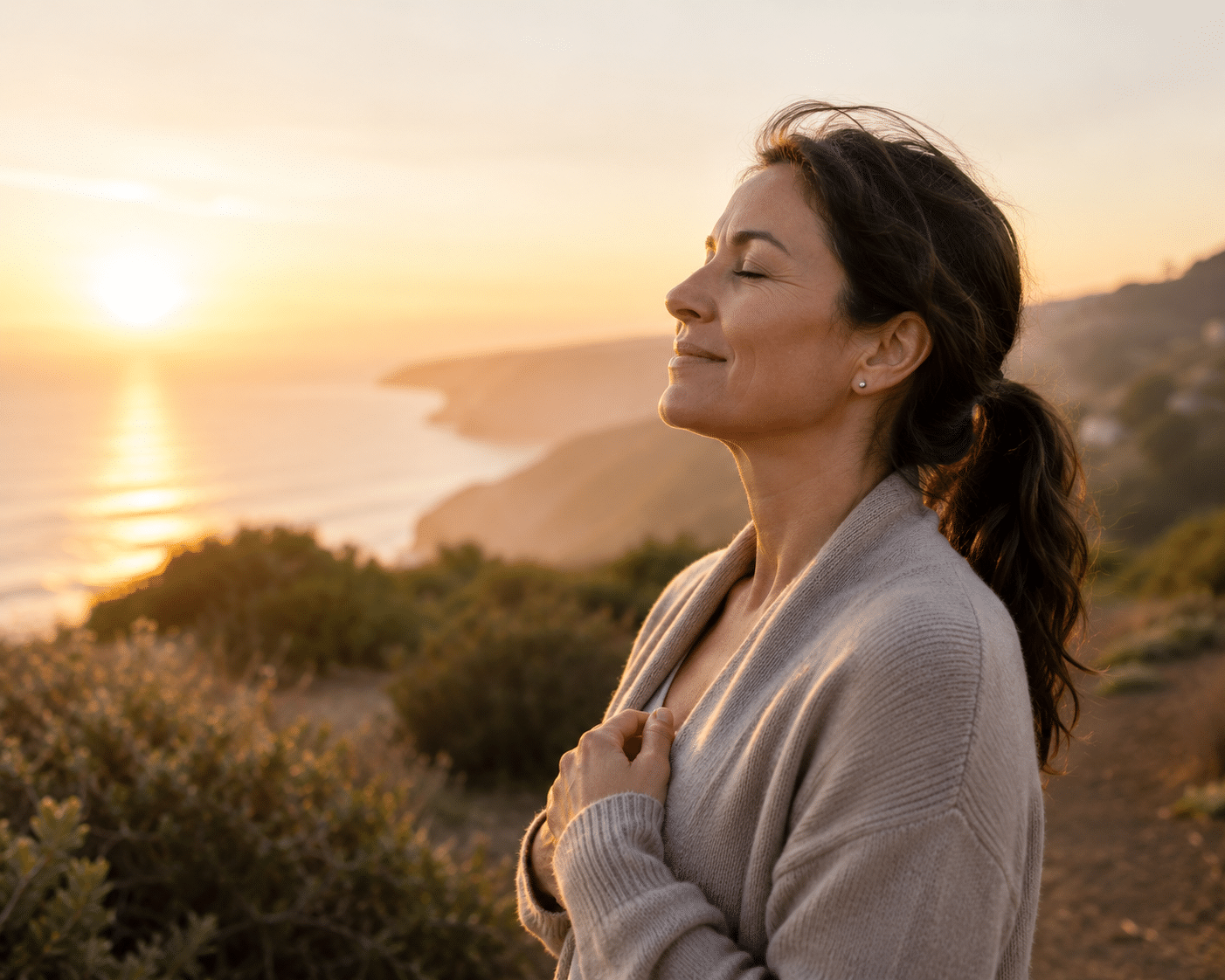 Calm reflective woman outdoors at sunrise on a healing wellness journey
