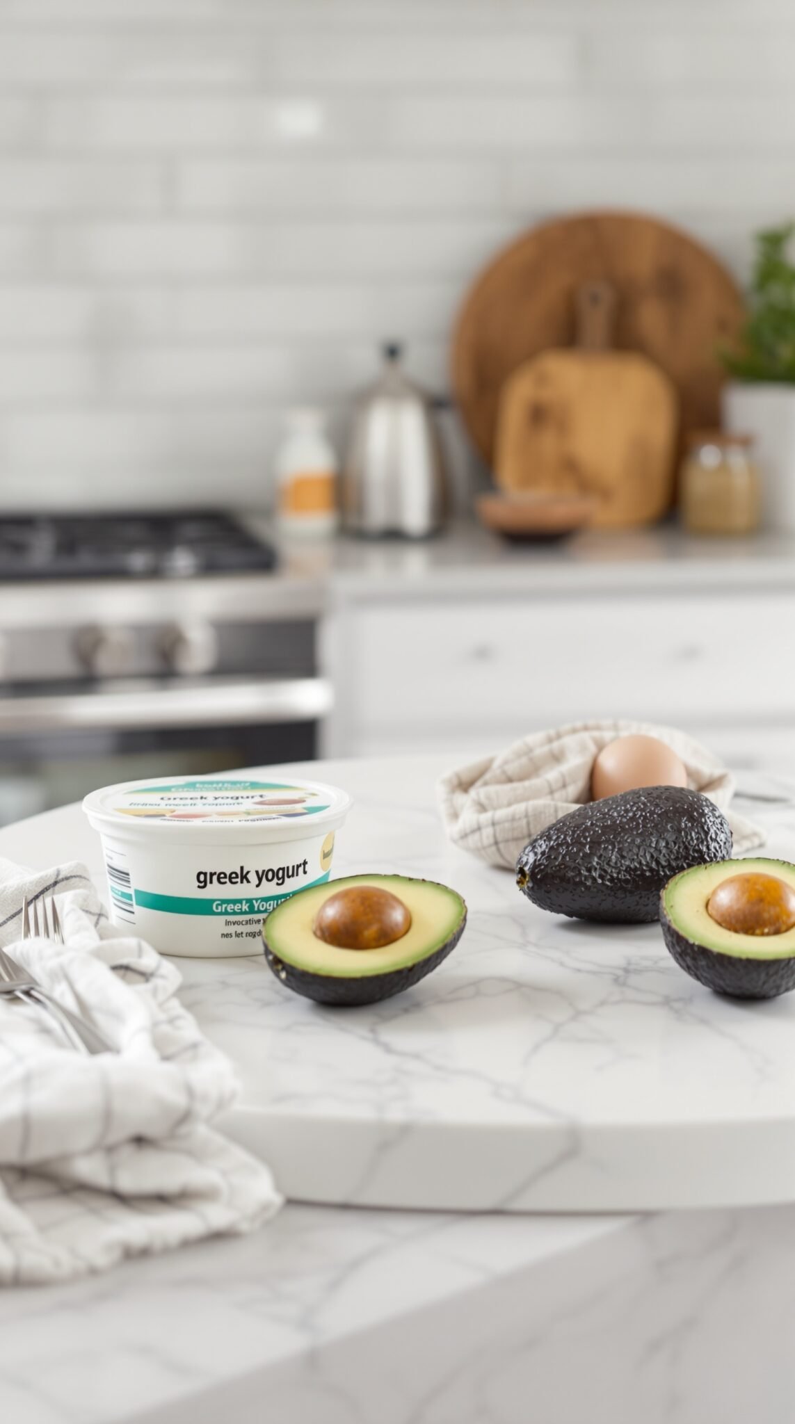 Healthy ingredient swaps with Greek yogurt and avocados on a kitchen counter.
