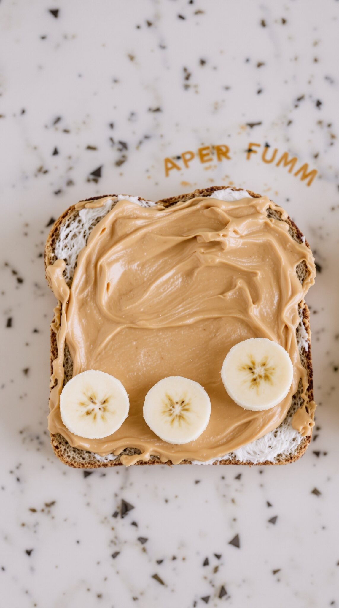 Peanut butter spread on whole grain bread topped with banana slices