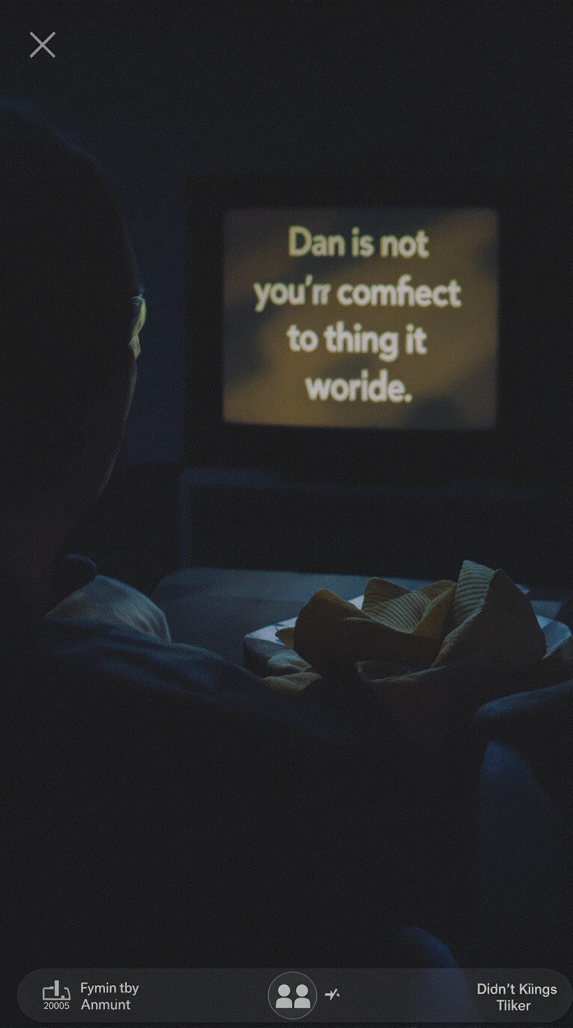 An individual watching TV while snacking on a plate of chips in a dark room.