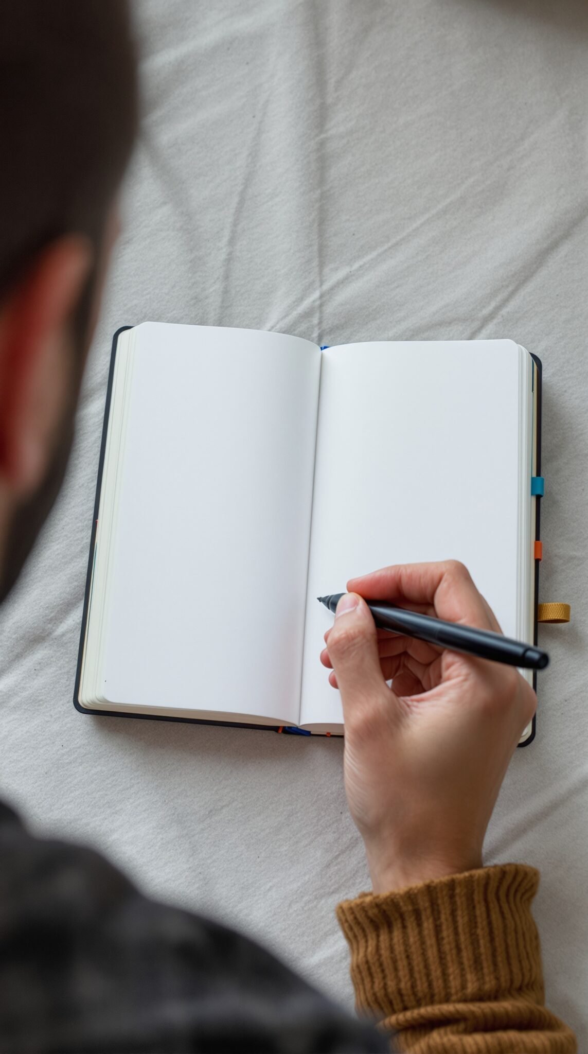 A person writing in a blank notebook, focused on tracking thoughts or food intake.